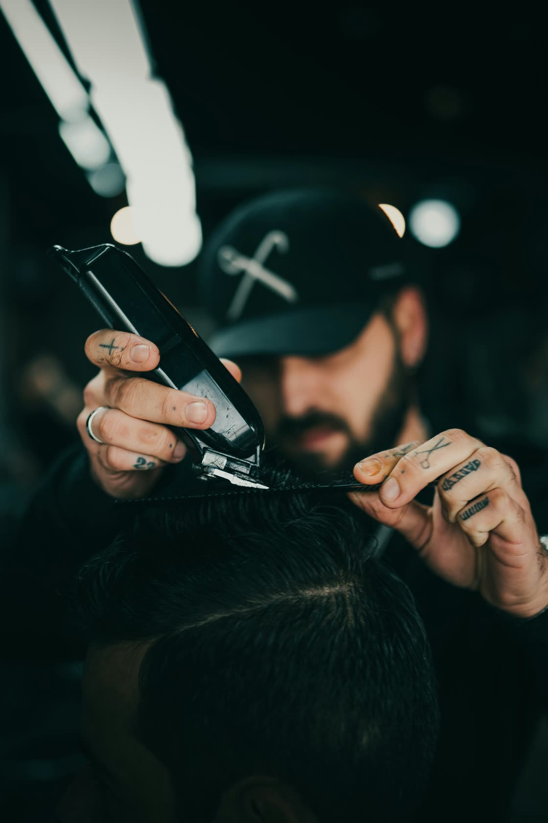 Barber blending a fade with clippers and comb